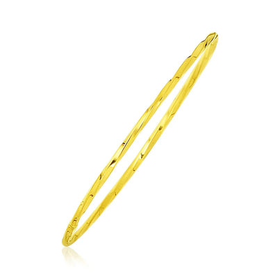 An image displaying 14k Yellow Gold Thin Twisted Shiny Bangle by Orca Market
