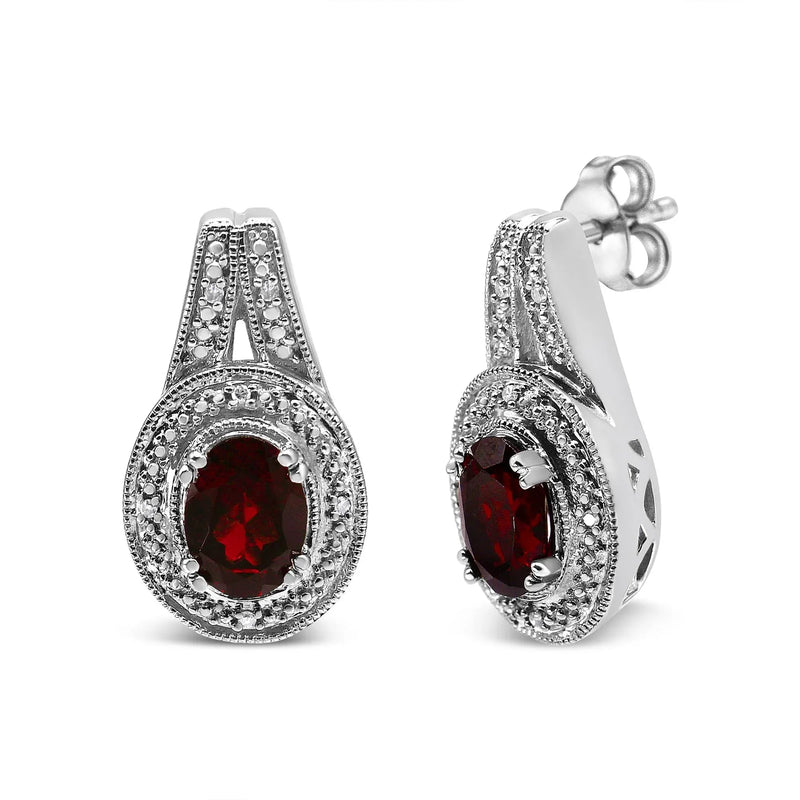 An image displaying .925 Sterling Silver Diamond Accent and 8x6mm Red Oval Garnet Stud Earrings (I-J Color, I1-I2 Clarity) by Infinite Jewels