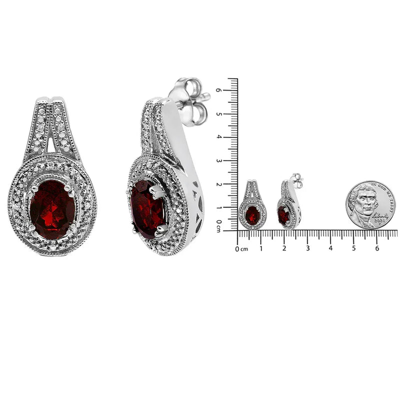 An image displaying .925 Sterling Silver Diamond Accent and 8x6mm Red Oval Garnet Stud Earrings (I-J Color, I1-I2 Clarity) by Infinite Jewels
