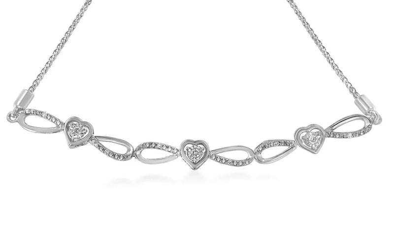 An image displaying .925 Sterling Silver 1/10 Cttw Diamond Triple Heart-in-Infinity Bolo Style Adjustable Bracelet (H-I Color, I2-I3 Clarity) by Infinite Jewels